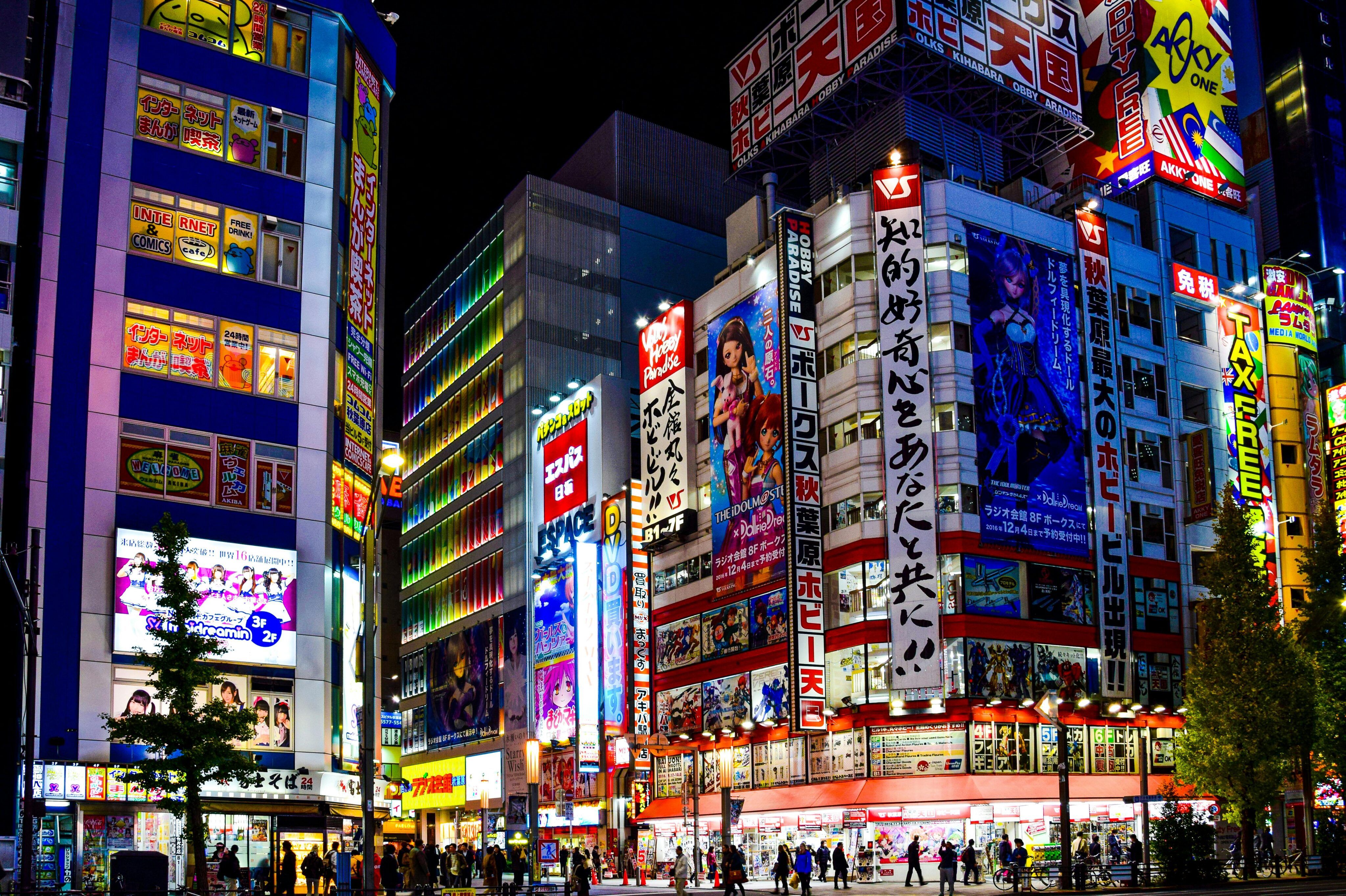 Letreiros em neon de prédios de jogos, animes e eletrônicos se destacam na noite de Akihabara, Japão