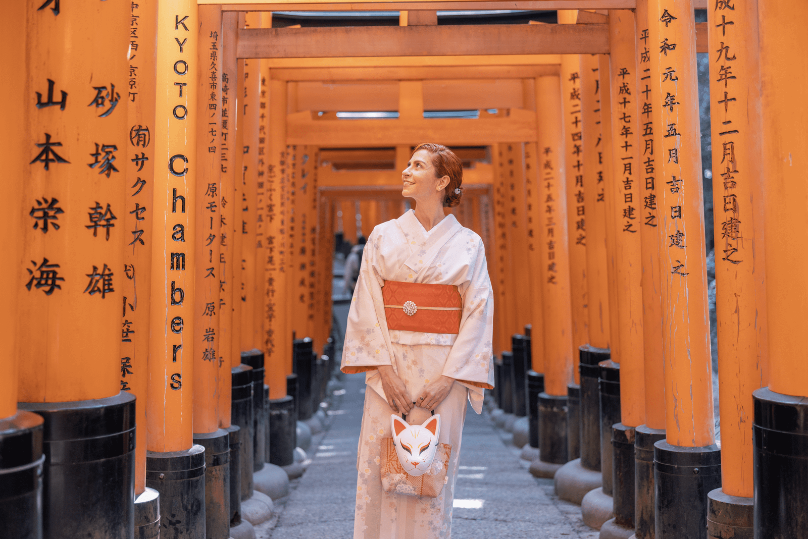 Kalu vestindo um kimono entre os Torii Gates em Fushimi Inari.
